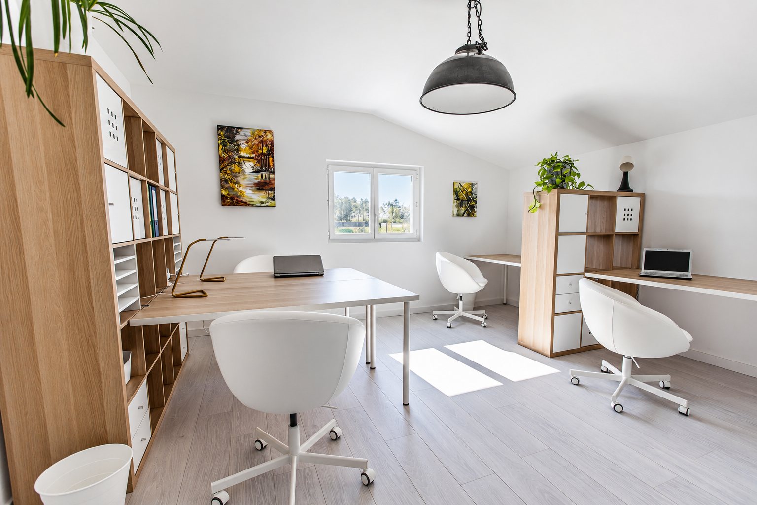 Espace de coworking lumineux avec mobilier en bois clair et fauteuils blancs
