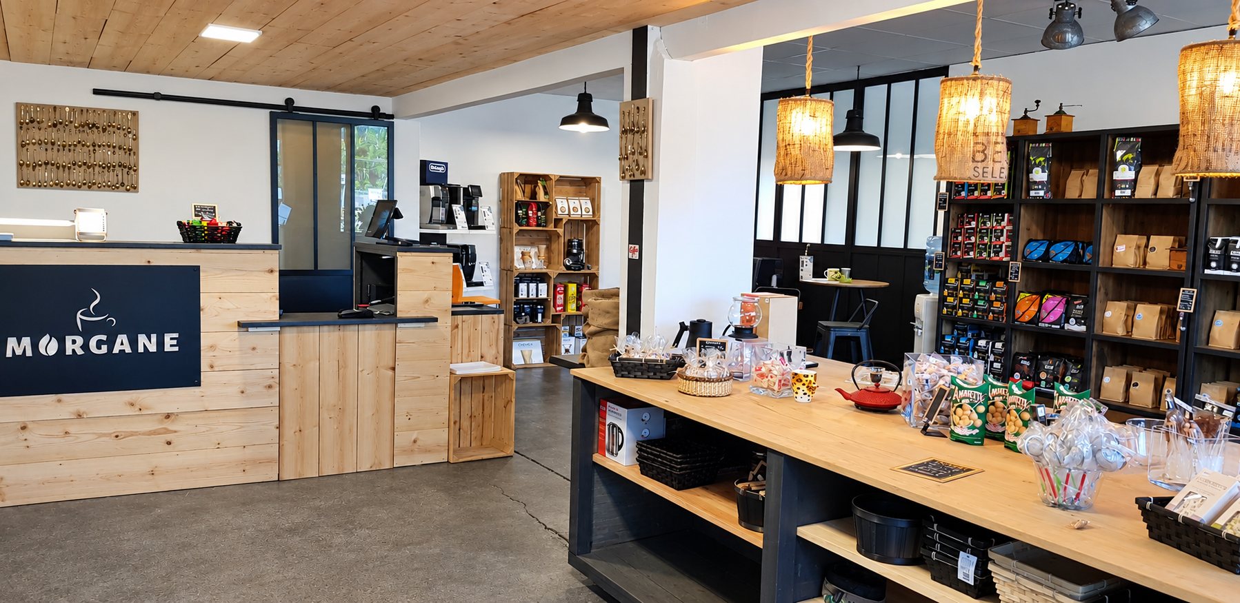 Intérieur de la boutique Morgane, comptoir en bois clair et étagères de cafés et de thés